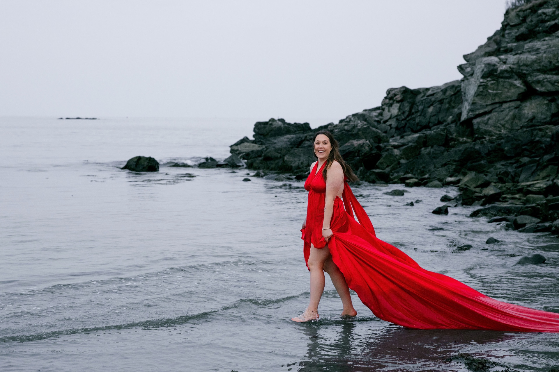Ashleigh, founder of A.C. Wade Studios, on the coast in a red dress